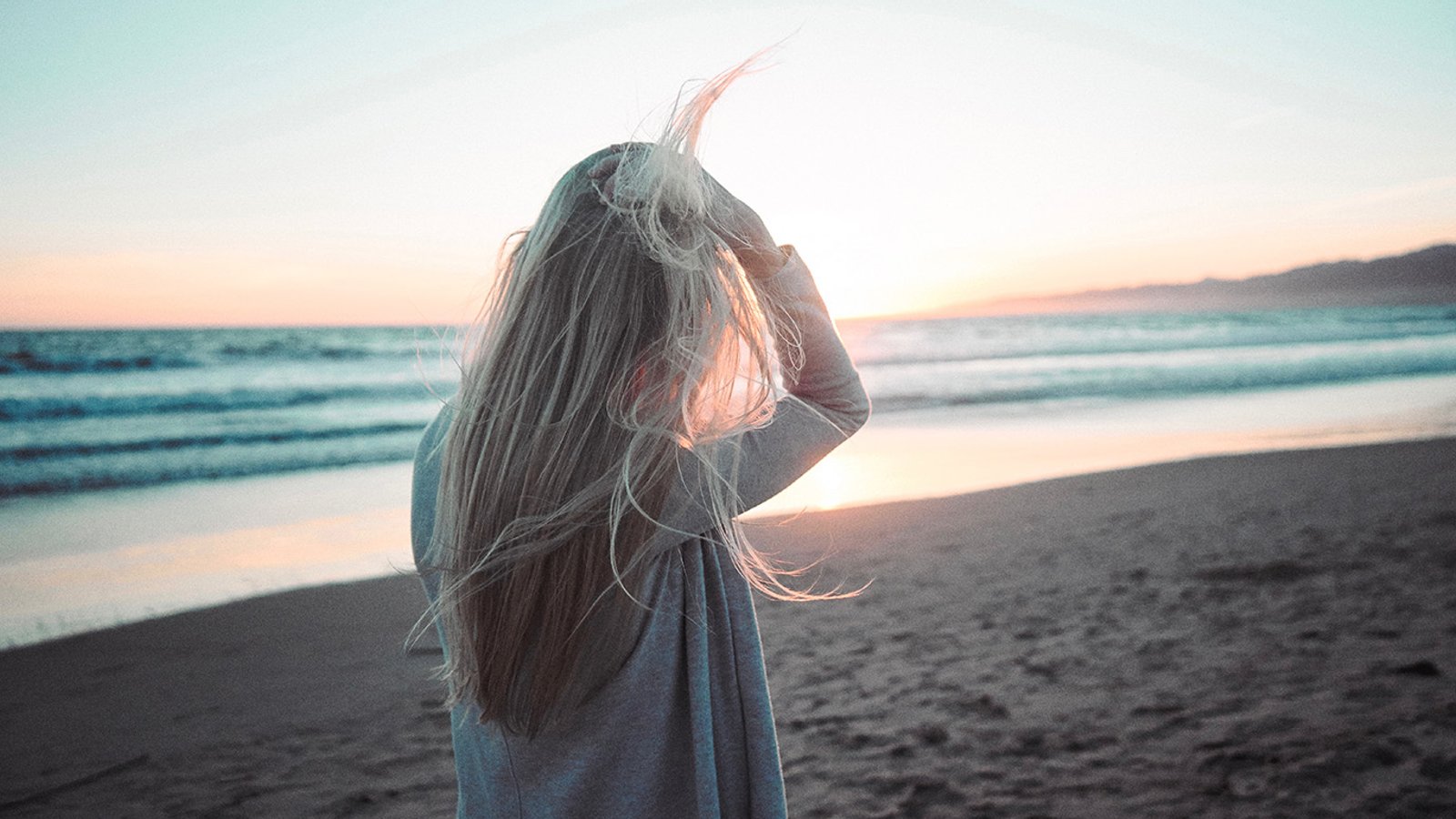 Девушка на море со спины со светлыми волосами