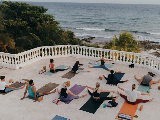 Group practicing yoga in one of the best spots for yoga retreats in Tulum