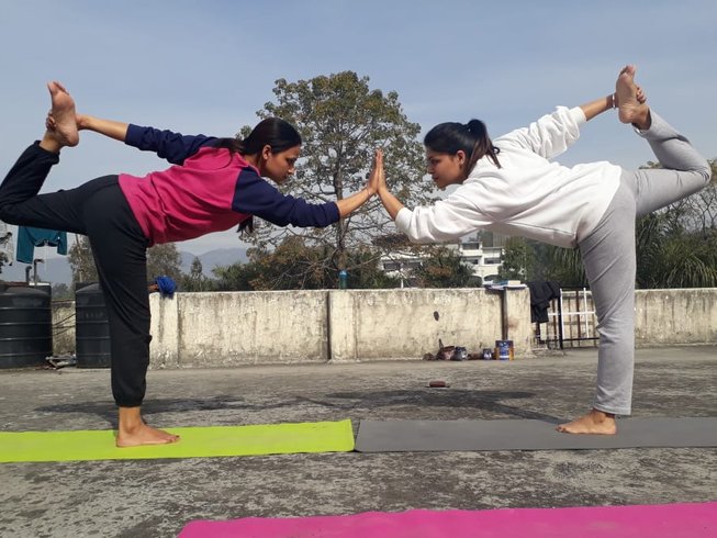 Two women in Yoga pose in a spendid spot for yoga retreats in India